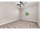 Neutral bedroom featuring a ceiling fan, plush carpet, and a window showcasing natural light and suburban views at 7756 Somersworth Dr, Kissimmee, FL 34747