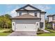 Charming two-story home boasts a white garage door, complemented by well-maintained landscaping and a brick driveway at 7756 Somersworth Dr, Kissimmee, FL 34747