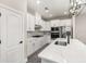 Modern kitchen features sleek white cabinets, stainless steel appliances, and a stylish quartz countertop island at 7756 Somersworth Dr, Kissimmee, FL 34747