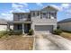 Charming two-story home features a gray exterior, well-maintained landscaping, and an attached two-car garage at 5597 Forest Ridge Dr, Winter Haven, FL 33881