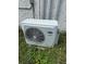 Carrier brand air conditioner in overgrown grass at 10931 Pathfinder Trl, Lakeland, FL 33809