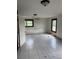 A damaged room with a damaged wall, damaged floors, and two windows at 10931 Pathfinder Trl, Lakeland, FL 33809