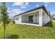 Backyard view of the home featuring a covered porch, sliding glass doors, and a well-maintained lawn at 16998 Cedar Valley Cir, Clermont, FL 34711