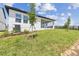 Backyard view with lush lawn, showcasing the home's covered patio and well-manicured landscaping at 16998 Cedar Valley Cir, Clermont, FL 34711