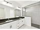 Modern bathroom featuring double sinks, granite countertops, and a walk-in shower at 16998 Cedar Valley Cir, Clermont, FL 34711