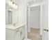 Bright bathroom with white cabinets, a modern vanity, and access to the walk-in closet at 16998 Cedar Valley Cir, Clermont, FL 34711