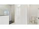 Bright bathroom featuring white toilet, tiled shower with dark tiling, and a walk-in closet at 16998 Cedar Valley Cir, Clermont, FL 34711