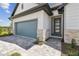 Close up on the home's exterior and gray garage door, showcasing stone and paved driveway at 16998 Cedar Valley Cir, Clermont, FL 34711