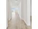 Bright hallway with light wood floors leads to a sunny living area at 16998 Cedar Valley Cir, Clermont, FL 34711