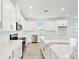Modern kitchen with white cabinets, stainless steel appliances, and a marble-topped island at 16998 Cedar Valley Cir, Clermont, FL 34711