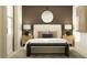 Stylish bedroom with contemporary decor, lamps, round mirror, and a dark bench at 4850 Yellow Elder Way, Kissimmee, FL 34758