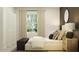Bright bedroom with a large window, a dark bench, and neutral decor at 4850 Yellow Elder Way, Kissimmee, FL 34758