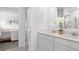 Contemporary bathroom showcasing a double vanity with quartz countertop and a view to an adjacent bedroom at 5686 Portico Pl, Kissimmee, FL 34758