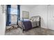 Stylized bedroom with simple bed frame and carpet. Blue details with plenty of natural light at 5686 Portico Pl, Kissimmee, FL 34758