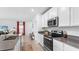Bright kitchen featuring an island, stainless appliances, white cabinetry, and an adjacent sitting area at 5686 Portico Pl, Kissimmee, FL 34758