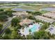 Aerial view of the community pool, clubhouse, and lush landscaping with nearby golf course and waterways at 1209 Payne Stewart Dr, Davenport, FL 33896