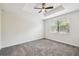 This carpeted bedroom has a tray ceiling, ceiling fan and a window with blinds at 1209 Payne Stewart Dr, Davenport, FL 33896