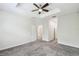 This carpeted bedroom features a tray ceiling, ceiling fan and an ensuite bathroom at 1209 Payne Stewart Dr, Davenport, FL 33896