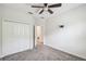 Bedroom features neutral carpet, a ceiling fan and closet with bi-fold doors at 1209 Payne Stewart Dr, Davenport, FL 33896