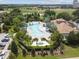 Aerial shot of the community pool, surrounded by lush landscaping, lounge chairs, and a luxurious spa at 1209 Payne Stewart Dr, Davenport, FL 33896