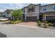 Well-maintained townhome with stone accents, brick driveway, two-car garage, and well-kept landscaping at 1209 Payne Stewart Dr, Davenport, FL 33896