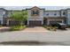 Attractive townhome with brick driveway, two-car garage, manicured landscaping, and architectural details at 1209 Payne Stewart Dr, Davenport, FL 33896