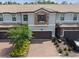 Beautiful townhome featuring a stone facade, brick driveway, and attached two-car garage at 1209 Payne Stewart Dr, Davenport, FL 33896