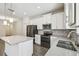 Modern kitchen with stainless appliances, white cabinetry, and a spacious island at 1209 Payne Stewart Dr, Davenport, FL 33896