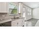 Bright kitchen with a stainless dishwasher, double sink, and windows with natural light at 1209 Payne Stewart Dr, Davenport, FL 33896
