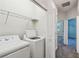 Modern laundry area featuring a side by side washer and dryer with shelving at 1209 Payne Stewart Dr, Davenport, FL 33896