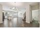 Open-concept living area with wood flooring, modern lighting, and adjacent kitchen and staircase at 1209 Payne Stewart Dr, Davenport, FL 33896