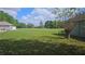 Expansive backyard featuring lush green grass, mature trees, and a blue sky with puffy white clouds at 6975 Sw 99Th St, Ocala, FL 34476