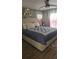 A sunlit bedroom features a plush bed, decorative headboard, and soft curtains for a comfortable retreat at 6975 Sw 99Th St, Ocala, FL 34476
