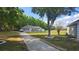 Charming single-story home with a long driveway, well-manicured lawn, and mature trees surrounding the property at 6975 Sw 99Th St, Ocala, FL 34476