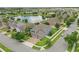 An aerial view of a well-maintained home with a lake view, lush landscaping, and a manicured lawn at 12243 Sawgrass Reserve Blvd, Orlando, FL 32824