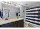 Bright bathroom features double vanity, and a blue and white striped shower curtain at 12243 Sawgrass Reserve Blvd, Orlando, FL 32824