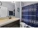 Bathroom features a vanity with dark cabinets and a shower/tub with blue patterned curtain at 12243 Sawgrass Reserve Blvd, Orlando, FL 32824