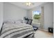 Bright bedroom with a striped bed, a treadmill by the window, and neutral decor at 12243 Sawgrass Reserve Blvd, Orlando, FL 32824