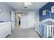 Bright Bedroom with a white crib, changing table and ample storage, with an ensuite bathroom at 12243 Sawgrass Reserve Blvd, Orlando, FL 32824