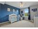 Charming Bedroom with blue accent wall, a white crib, and a cozy rocking chair at 12243 Sawgrass Reserve Blvd, Orlando, FL 32824