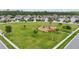 Aerial view of a community park featuring a playground and a vast open grassy area, with neighborhood homes at 12243 Sawgrass Reserve Blvd, Orlando, FL 32824