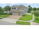 Aerial view of a home with a brick driveway, three-car garage, manicured lawns, and fenced yard at 12243 Sawgrass Reserve Blvd, Orlando, FL 32824