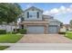 Charming two-story home featuring a brick-accented facade, three-car garage, and a well-manicured lawn at 12243 Sawgrass Reserve Blvd, Orlando, FL 32824