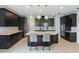 Modern kitchen featuring dark cabinets, granite countertops, and a center island with seating at 12243 Sawgrass Reserve Blvd, Orlando, FL 32824
