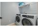 Modern laundry room featuring front loading washer and dryer with wire rack shelving above at 12243 Sawgrass Reserve Blvd, Orlando, FL 32824