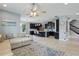 Open-concept living area with a sectional sofa, tiled floors, and a modern kitchen at 12243 Sawgrass Reserve Blvd, Orlando, FL 32824