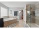 Main bathroom featuring a soaking tub, glass enclosed shower, and a walk-in closet at 12243 Sawgrass Reserve Blvd, Orlando, FL 32824