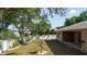 Landscaped backyard with a charming fountain, mature trees, and a white fence at 1472 Muir Cir, Clermont, FL 34711