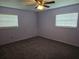 A standard bedroom with neutral paint, ceiling fan, two windows, and wall-to-wall carpeting at 4506 Se 7Th Pl, Ocala, FL 34471