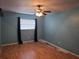 Bedroom featuring blue walls, ceiling fan, one window with dark curtains, and light flooring at 4506 Se 7Th Pl, Ocala, FL 34471
